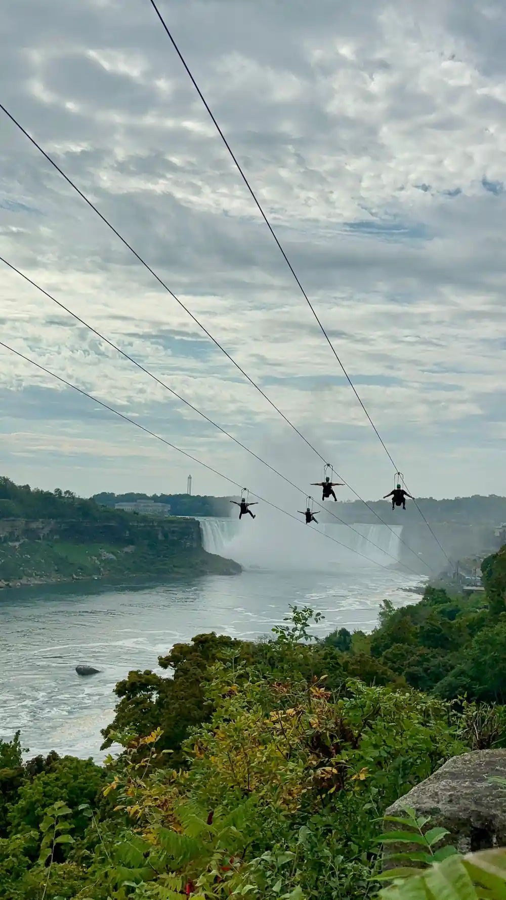 Four riders side by side against the falls