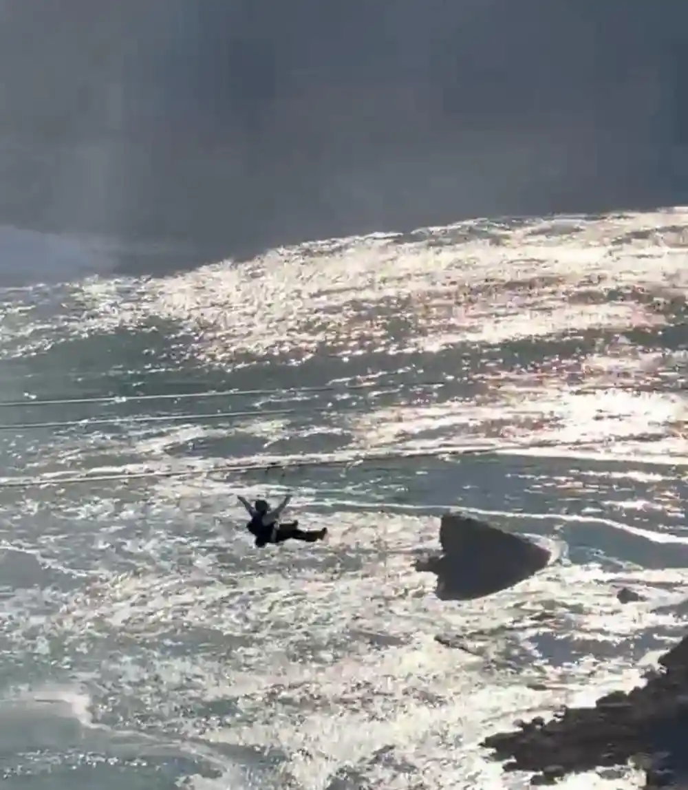 A rider small above the white water
